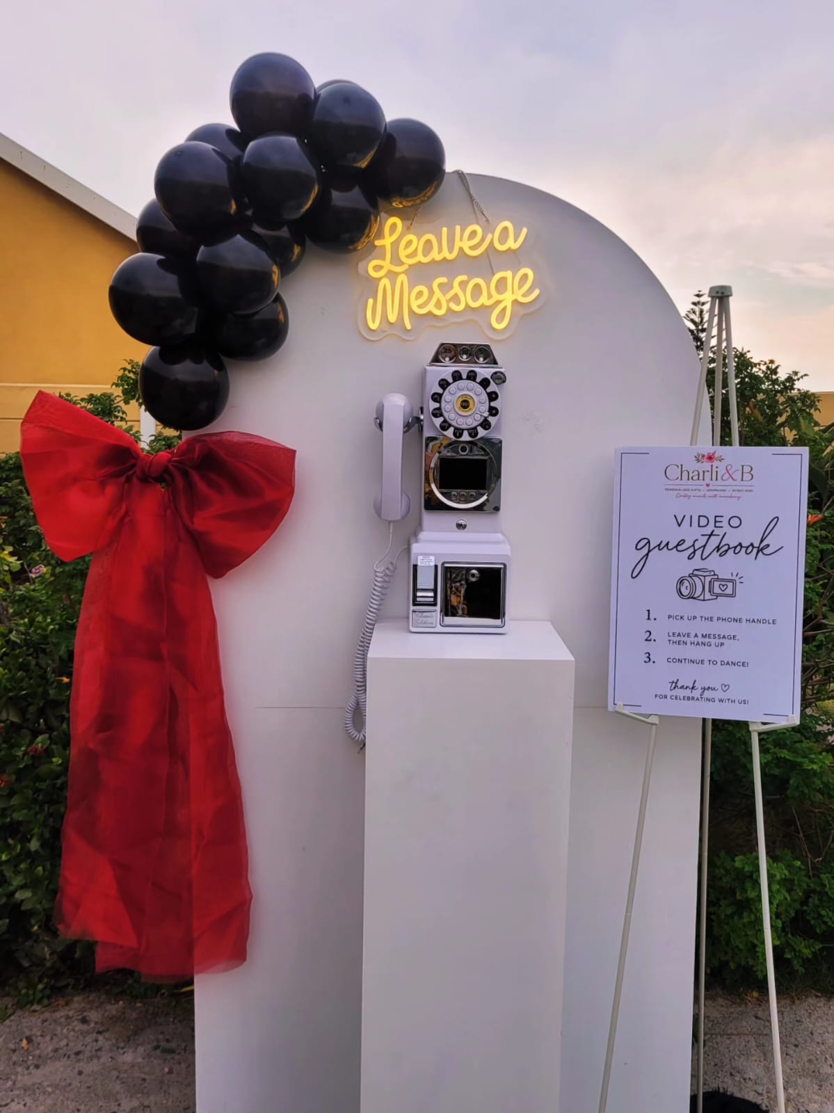 Video guestbook stand with colourful rainbow balloon garland and crab balloon